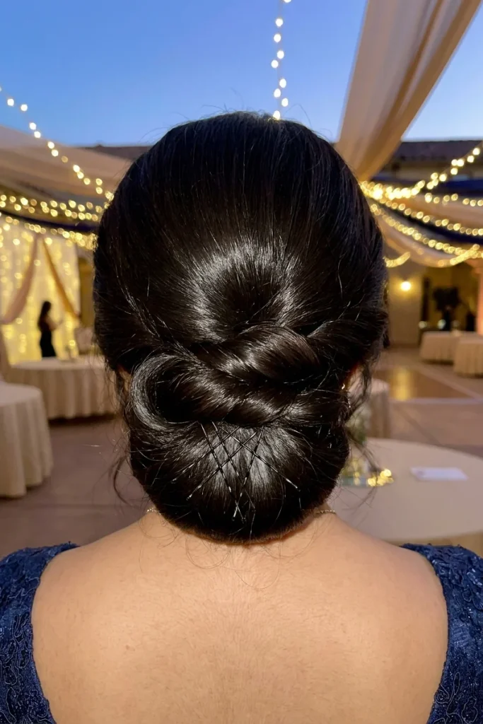 Classic prom updo twisted chignon with cross-pin pattern, back view, formal prom venue setting