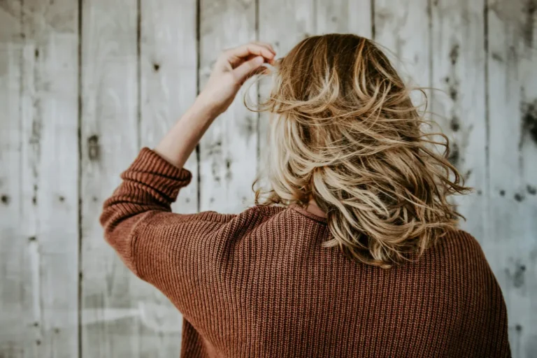 Woman with wavy layered hair showing visible layer texture and movement, rustic wooden background