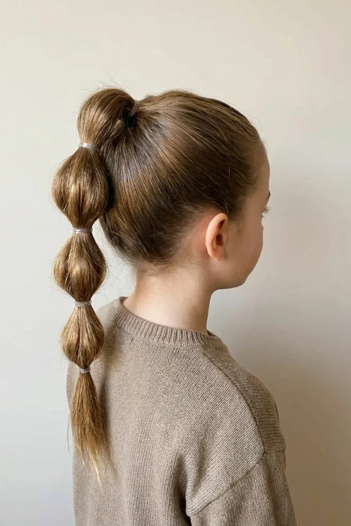 High bubble ponytail with rounded segments, side profile view