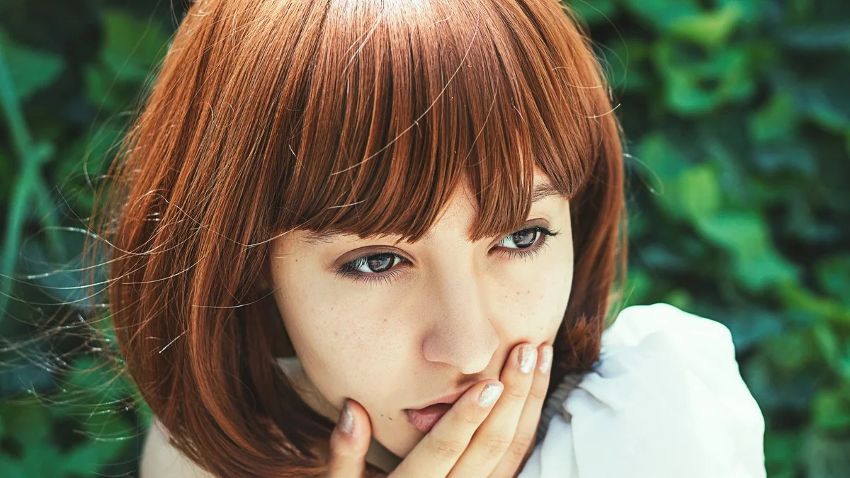 Woman with new bob haircut touching her face, adjusting to the change