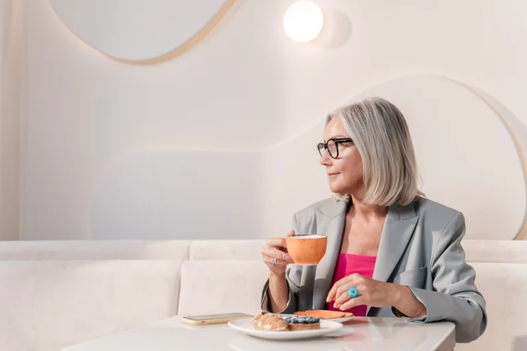 Woman with a healthy shiny silver gray bob smiling in a cafe