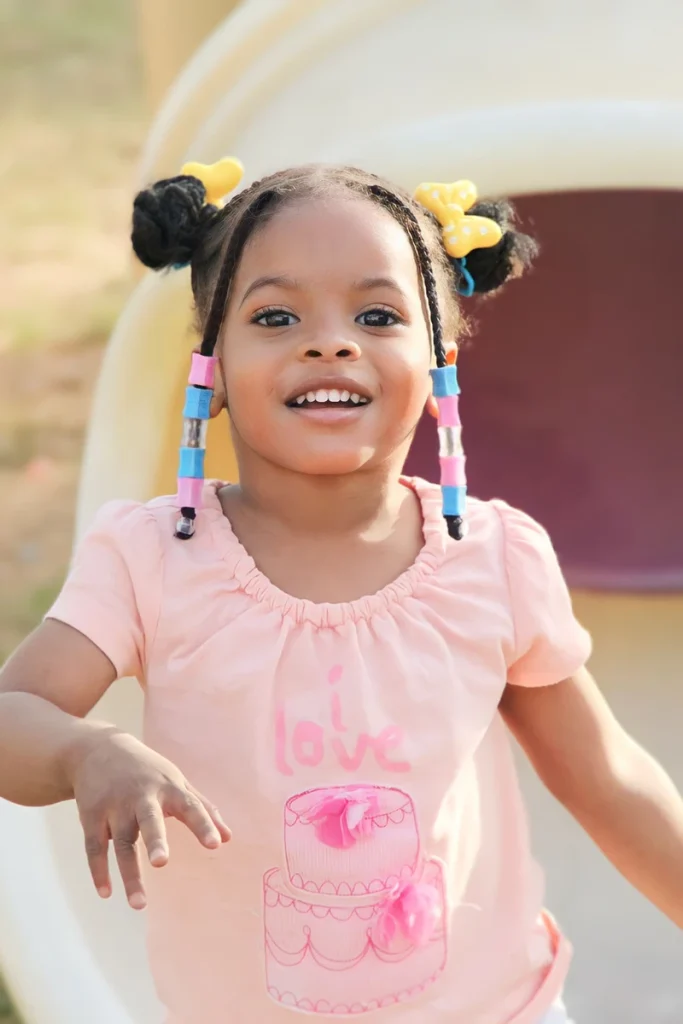 Space buns hairstyle on a young girl playing outdoors