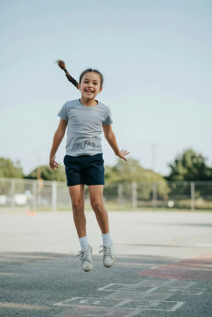 High braided ponytail on a young girl jumping at recess