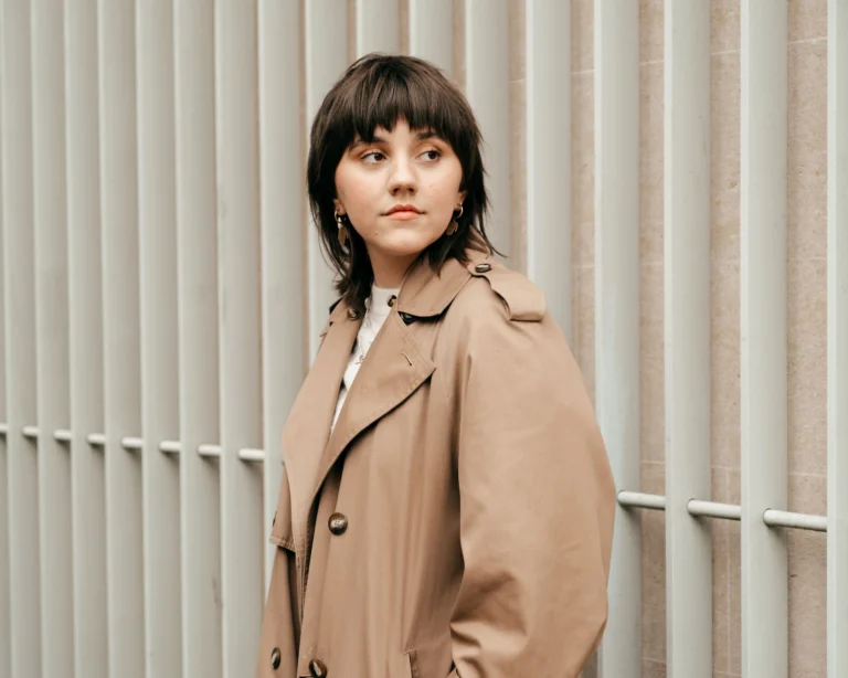 Woman with a choppy layered wolf cut featuring bangs and shaggy texture