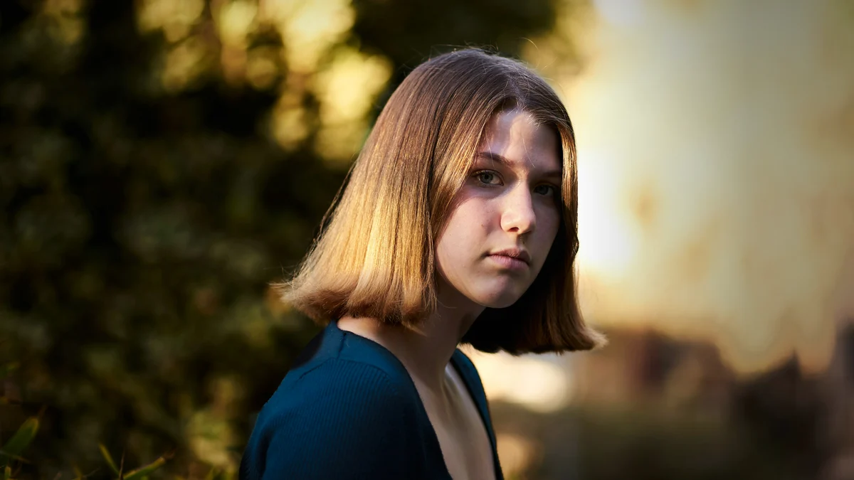 Woman with fine, straight light brown hair cut in a blunt shoulder-skimming bob with a solid, even hemline
